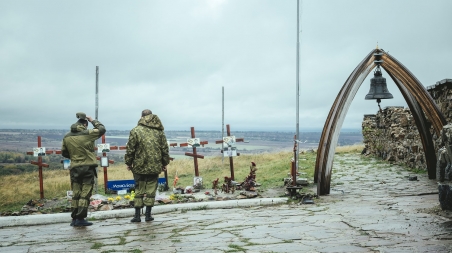 Unweit der russischen Grenze auf der Anhöhe von Saur-Mogila trauern zwei Kämpfer der pro-russischen Seite um ihre Kameraden, die bereits 2014 im Kampf mit der ukrainischen Armee gefallen sind. / Foto: Florian Bachmeier, n-ost