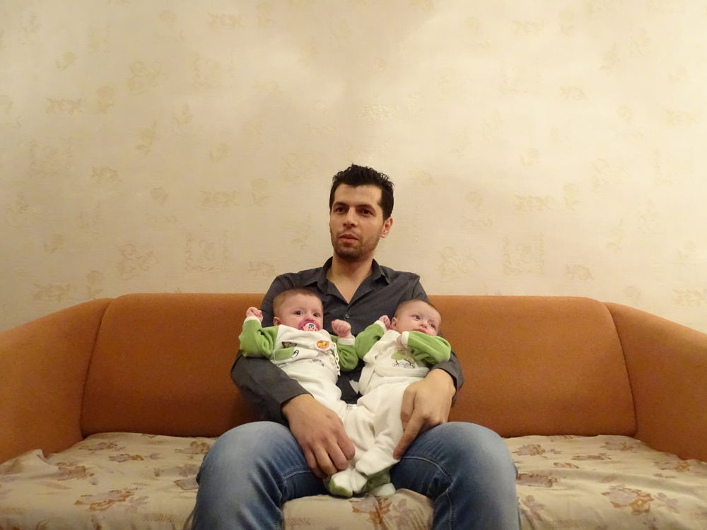 Shaadi mit seinen Zwillingen in der Moskauer Wohnung. Die beiden Mädchen sind zwar in Russland geboren, haben aber keine offiziellen Papiere. / Foto: Simone Brunner, n-ost