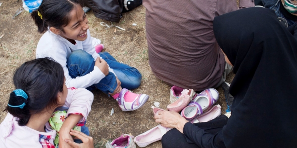 Freude über neue Schuhe: Viele Belgrader helfen den Flüchtlingen, die am Bahnhof Zwischenstopp machen. Hier einer Familie aus Afganistan. / Foto: Marko Risovic, Kamerades, n-ost